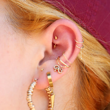 stack of earlobe and helix piercings on a Portland woman's ear
