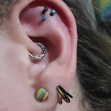 trio of cartilage piercings with a daith and two earlobe ear piercings done at the IRIS Boulder Colorado studio shop