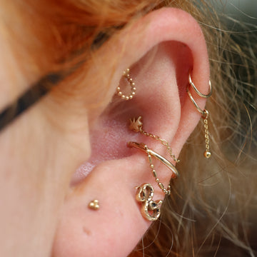 close up of an ear with lobe and helix piercings done at the IRIS Portland Oregon shop
