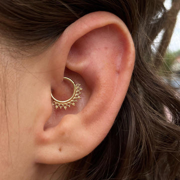 intricate gold daith ear piercing done at the Grand Rapids MI IRIS Piercing Studio