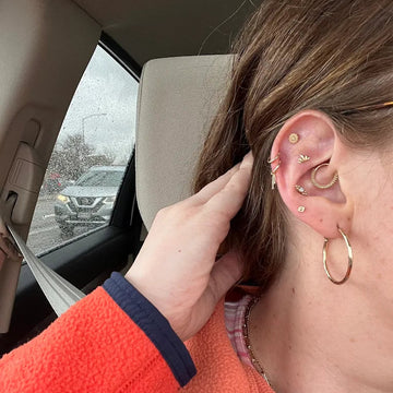 ear close up of multiple earlobe piercings paired with a triple helix cartilage stack and a daith done at the IRIS Boulder CO piercing shop