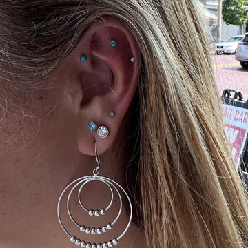 ear showcasing multiple difference earlobe and cartilage piercings completed at the Grand Rapids MI IRIS Piercing Studio